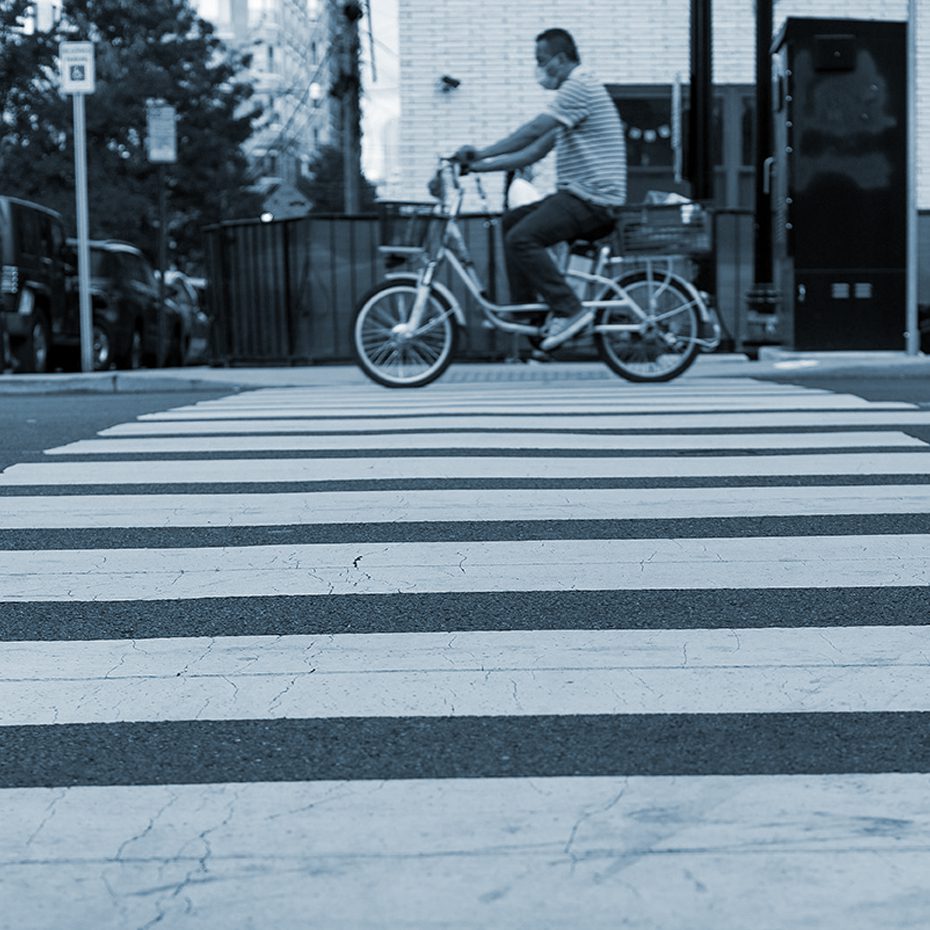 Man rides bicycle through a crosswalk