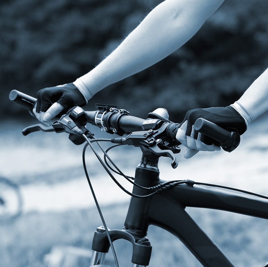 Man grips the handle bars of his bicycle