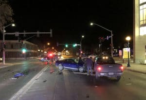 A pickup truck is stopped on the street after another car has crashed into it