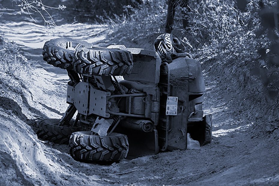 ATV on it's side on a trail