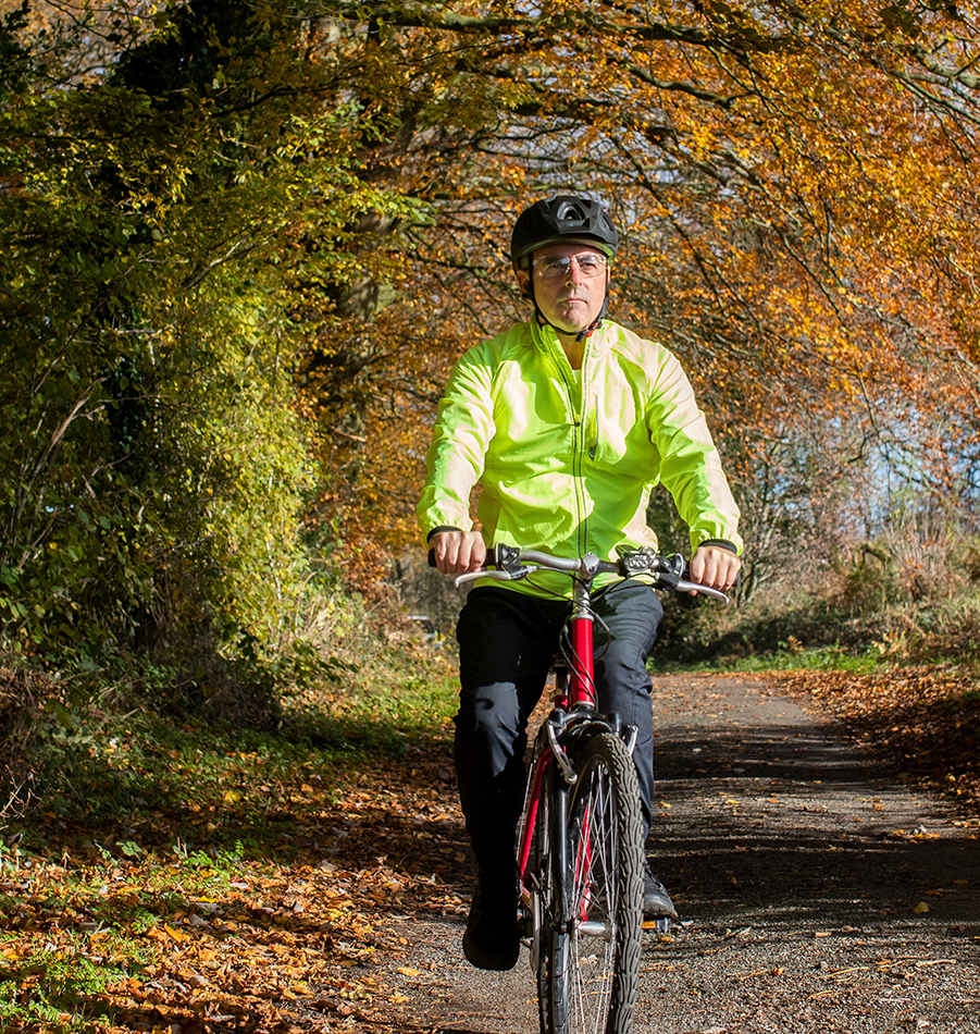 Bicyclist rides through the park on a fall day.