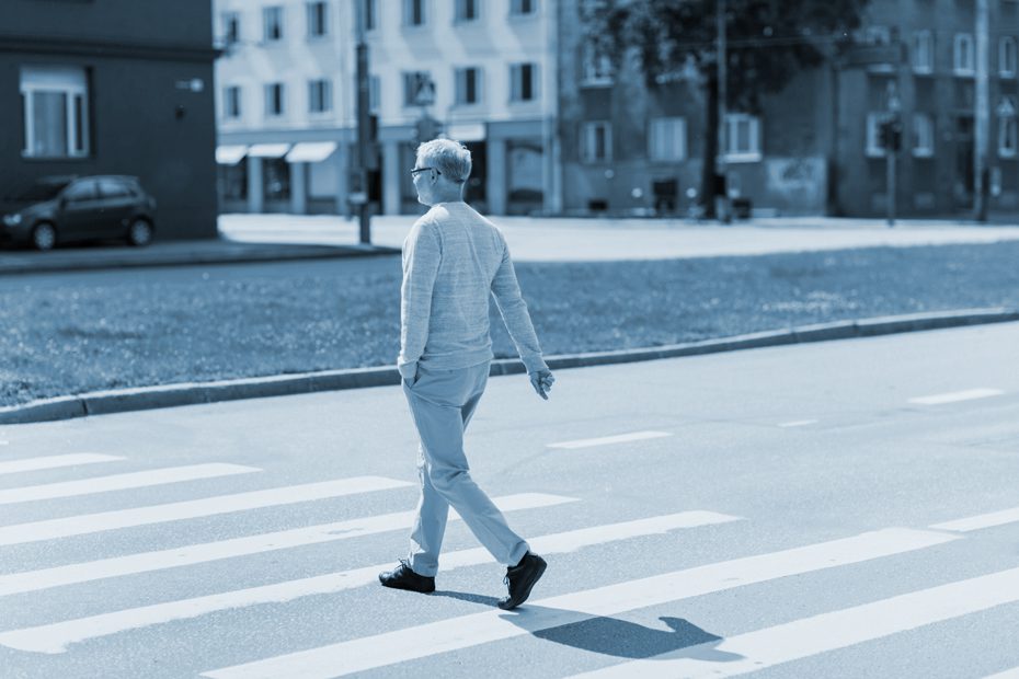 Man walks across a city crosswalk
