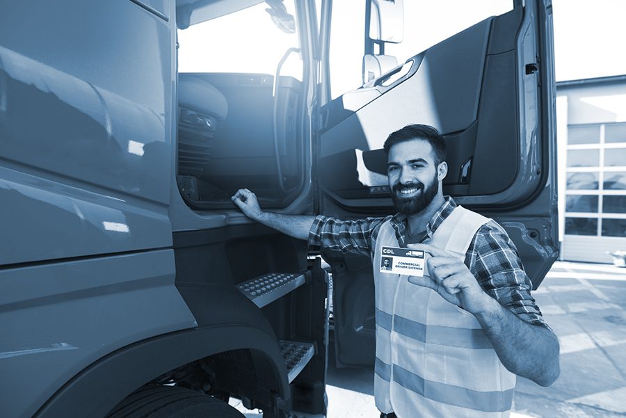 New truck driver show CDL while standing next his truck 