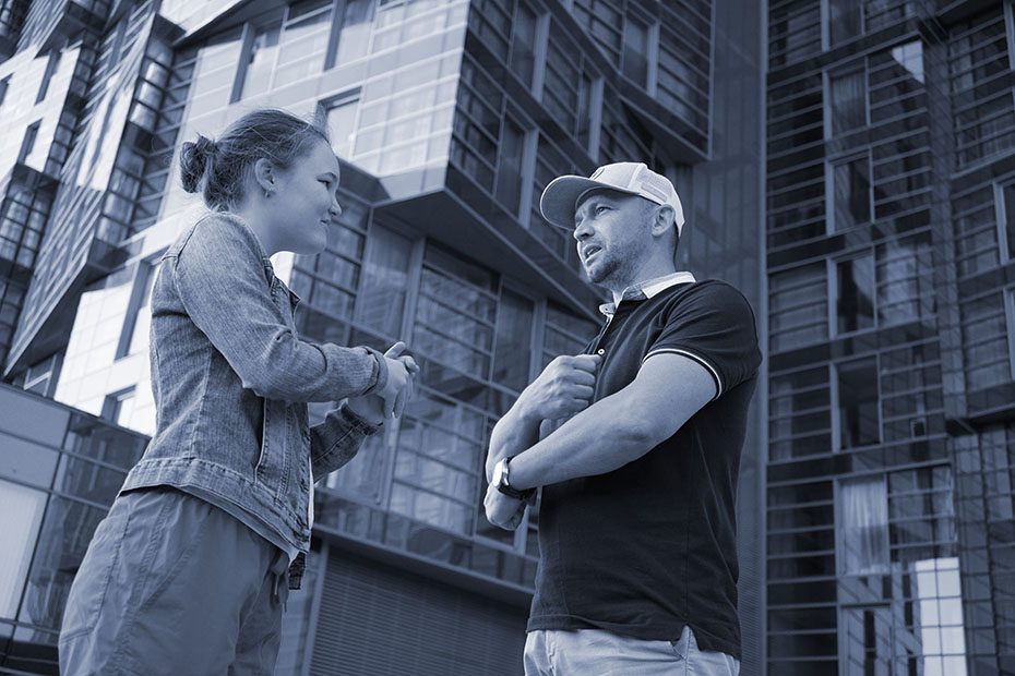 man and woman have a discussion on a city block