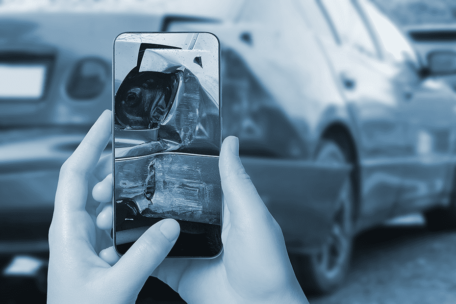 Person takes photos of car damage after accident