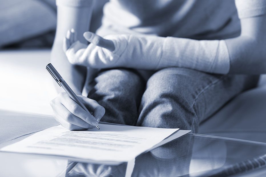 Injured woman with bandaged arm signs document