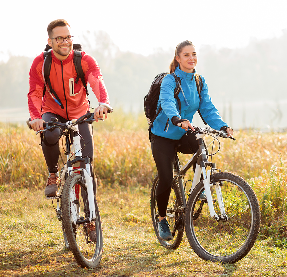 Two bicyclists ride on a trail side by side