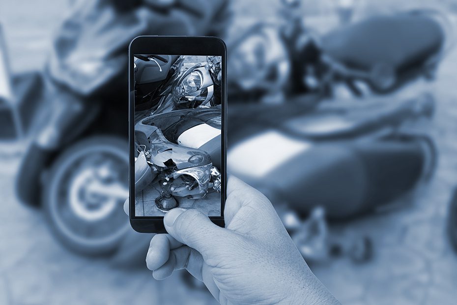 Taking a photo of the damage after a motorcycle accident.