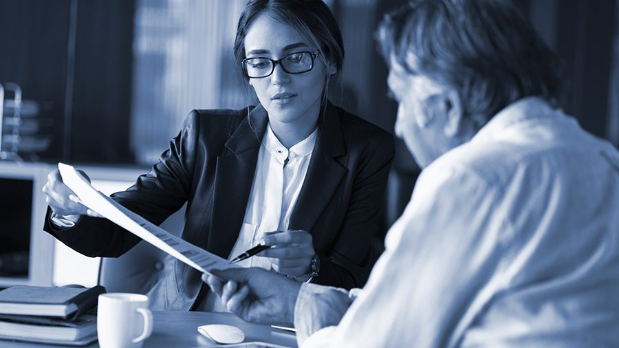 Attorney reviews paperwork with client at a coffee shop