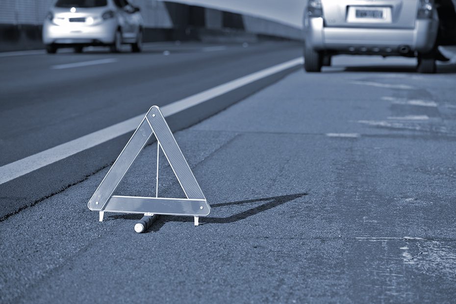 Emergency triangle sign protects car on the side of the road