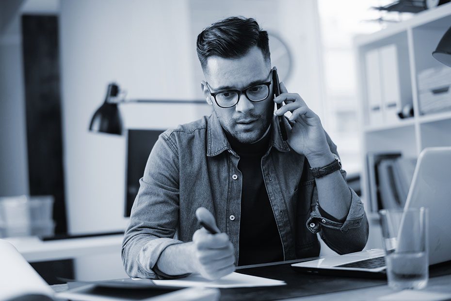 Man on the talking on the phone is his office