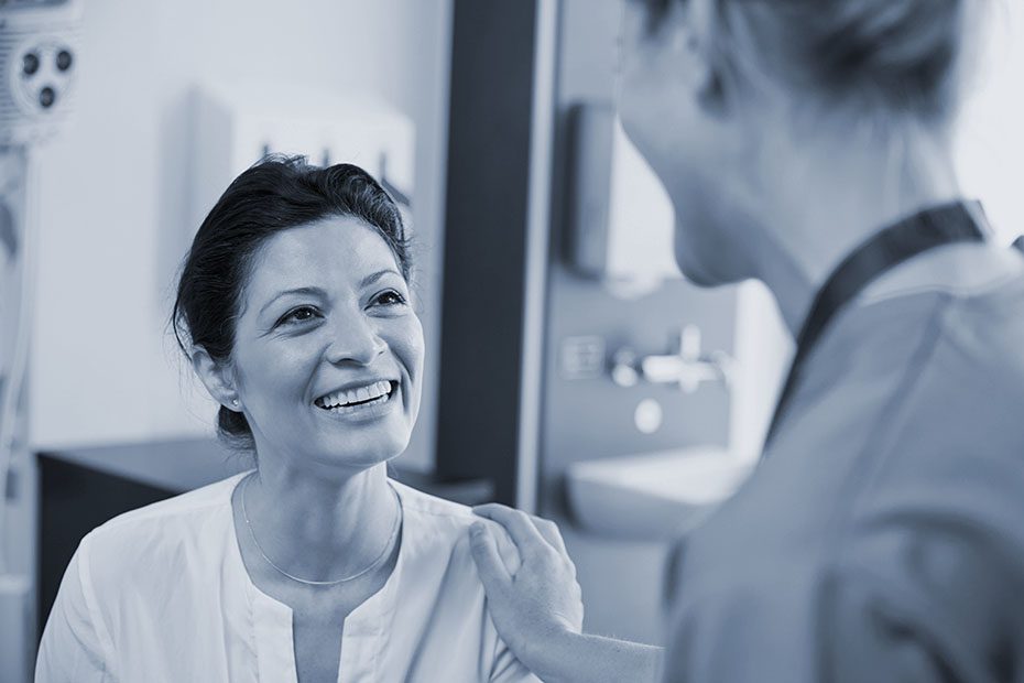 Female patient being reassured by doctor in hospital room