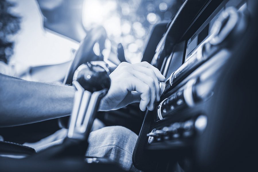 Person adjusts the volume on their car radio