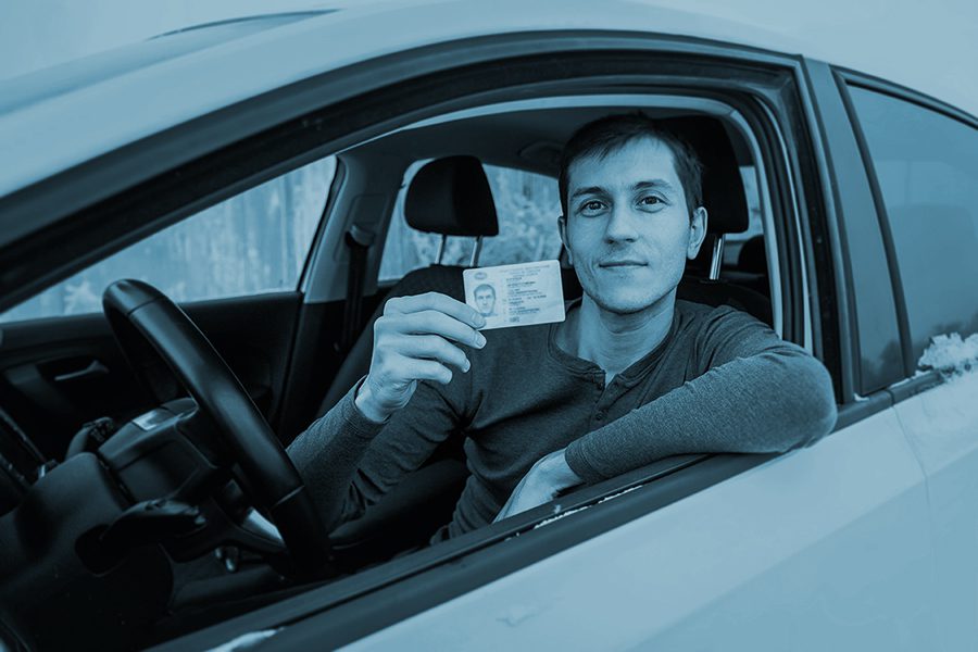 new driver shows in his license in the car window