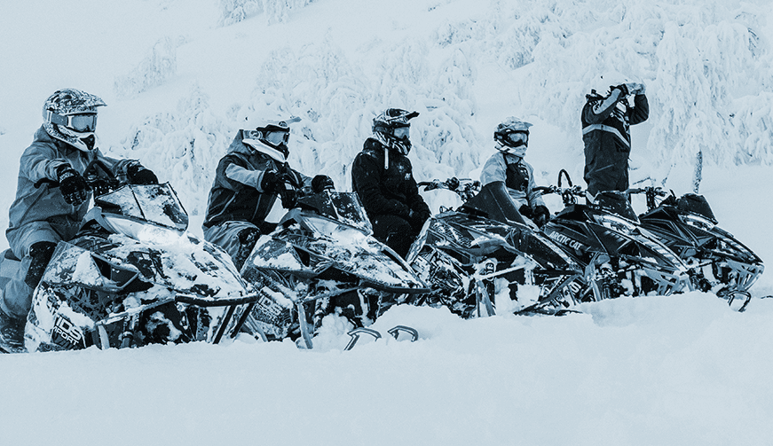 Snowmobile riders in a line