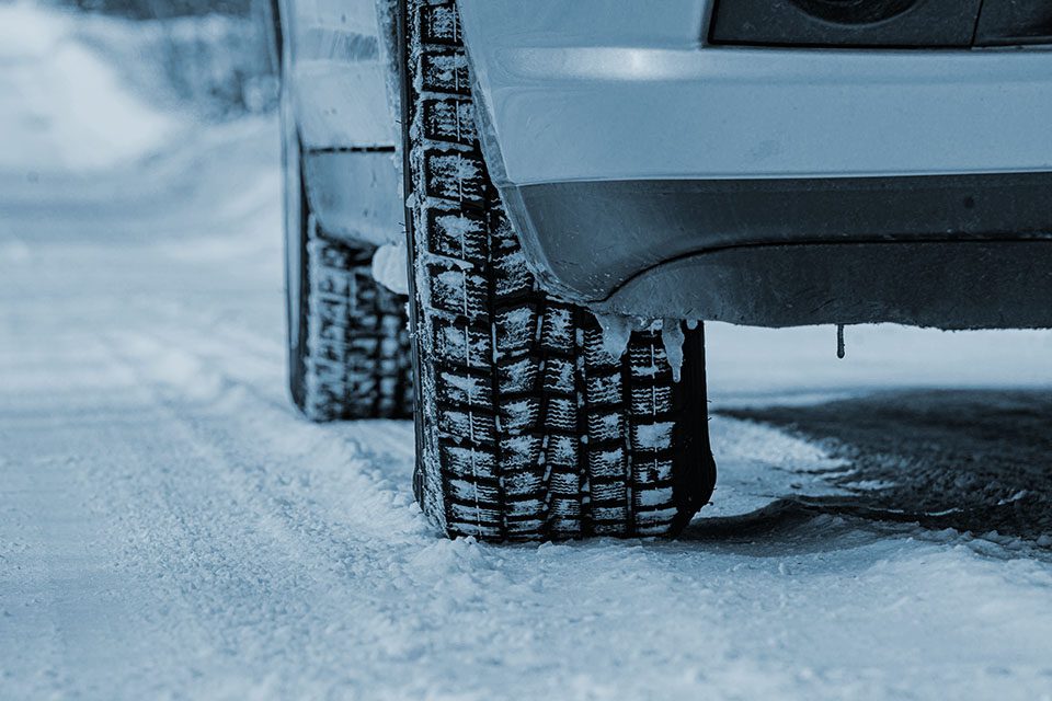 Close-up shot of winter tires driving on the snow