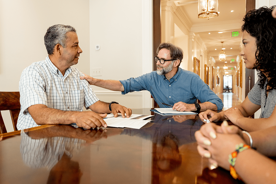 Attorney comforts client in a meeting room