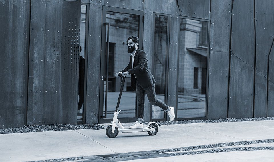 Man rides electric scooter on the sidewalk