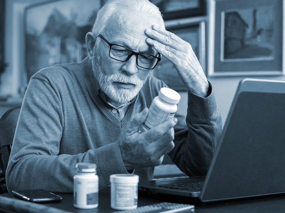 Senior ill man taking pills from the bottle at home