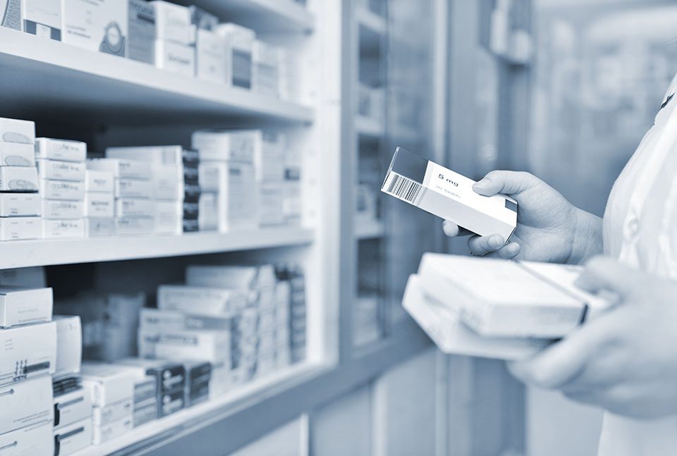 Pharmacist holds a box of medicine in a drugstore