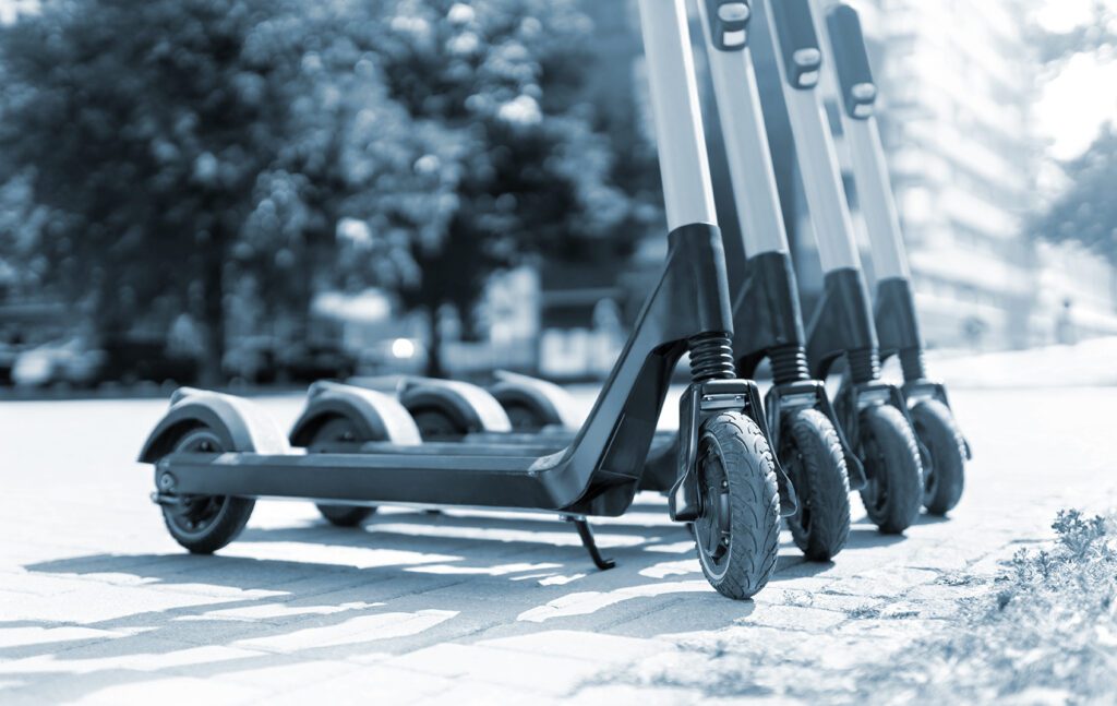 line of scooters on a park sidewalk
