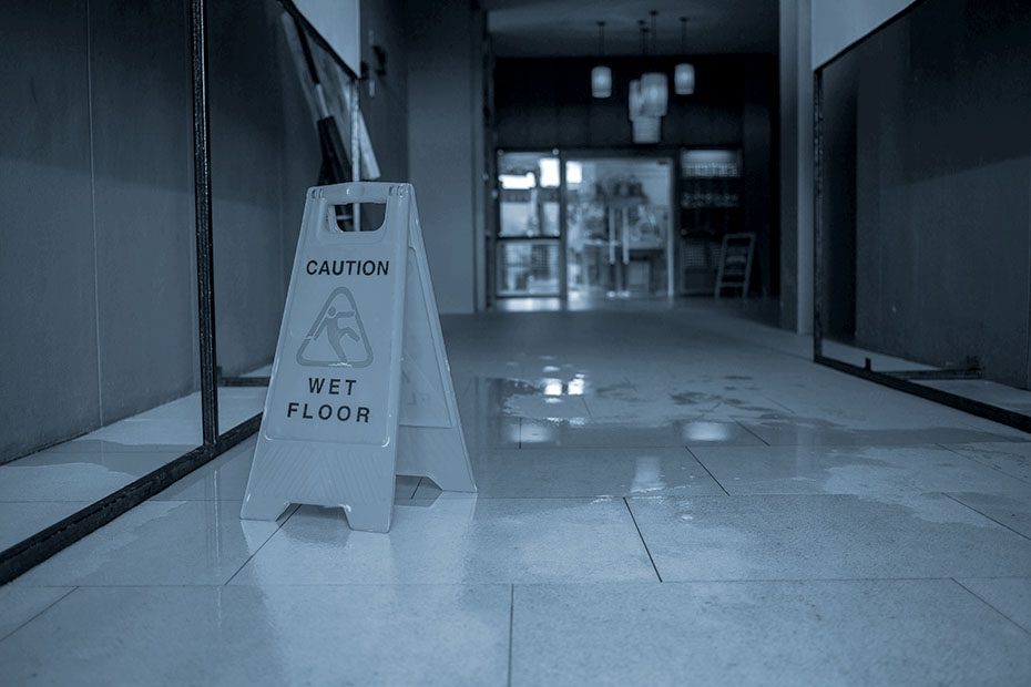 Caution: wet floor sign over a puddle in a hallway