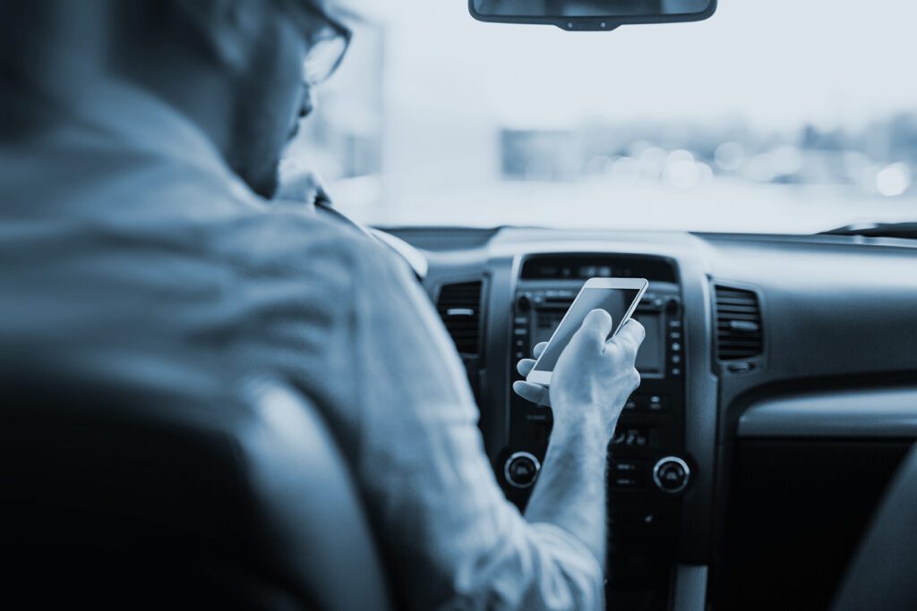 Distracted driver looks down a cell phone.