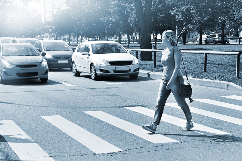 Pedestrian on a crosswalk in front of stopped cars