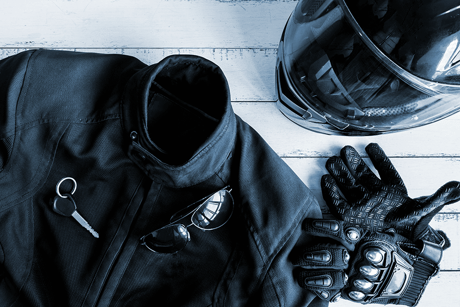 Motorcycle jacket, gloves, helmet, and sunglasses on a table