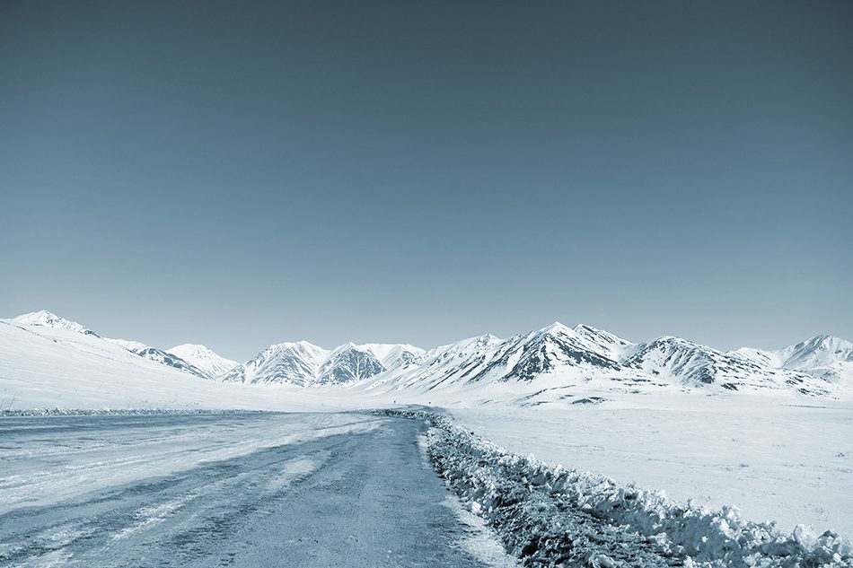 Dalton Highway in Alaska. Dangerous Icy road in desolate snowy mountain region