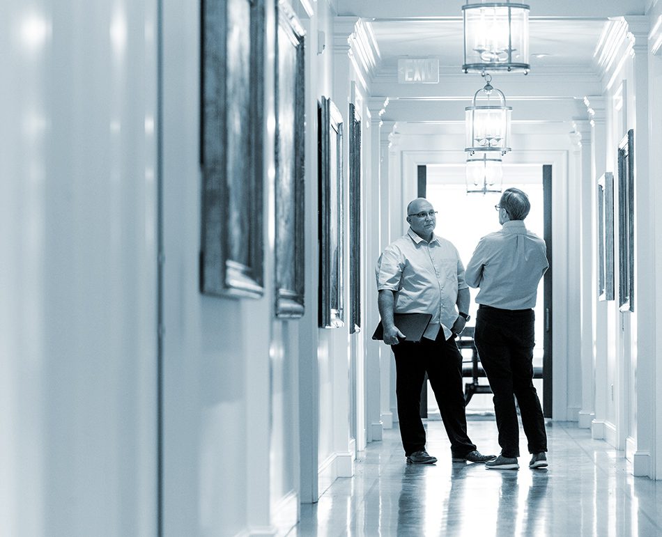 Attorneys and client discuss case in the halls of a law firm