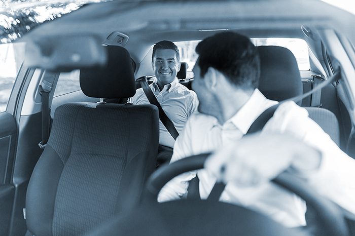 A man is driving distracted and looking at his passenger in the back seat