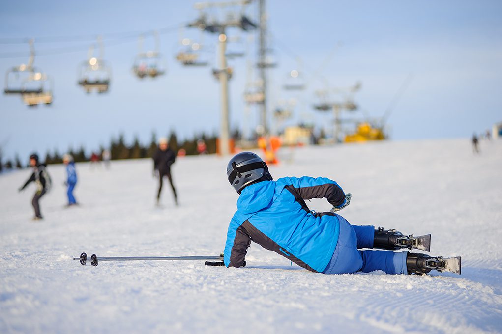 Skier falling and suffering an injury in the winter time