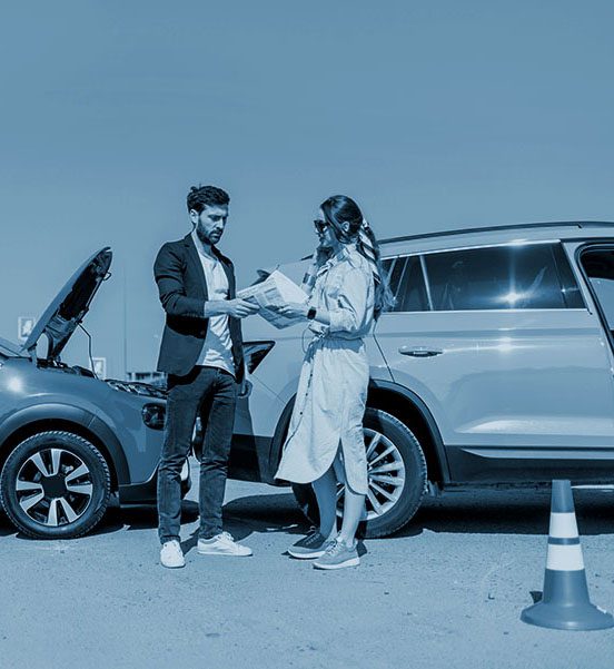 Man and woman arguing, standing together on the road with their cars on the background after the car accident