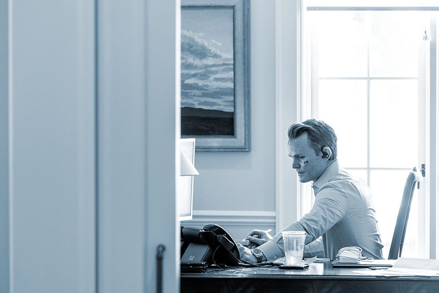 Attorney sits at his desk help a client via headset.