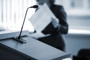 Close up focus on courtroom microphone with attorney in the background.