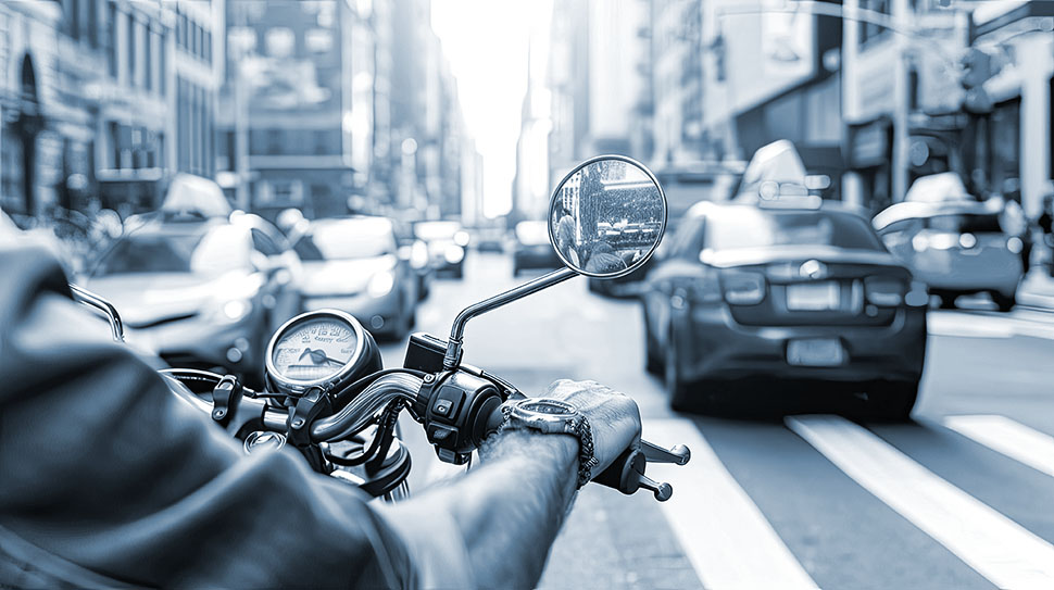 Motorcyclist navigates urban traffic, leaving a trail of excitement in their wake.
