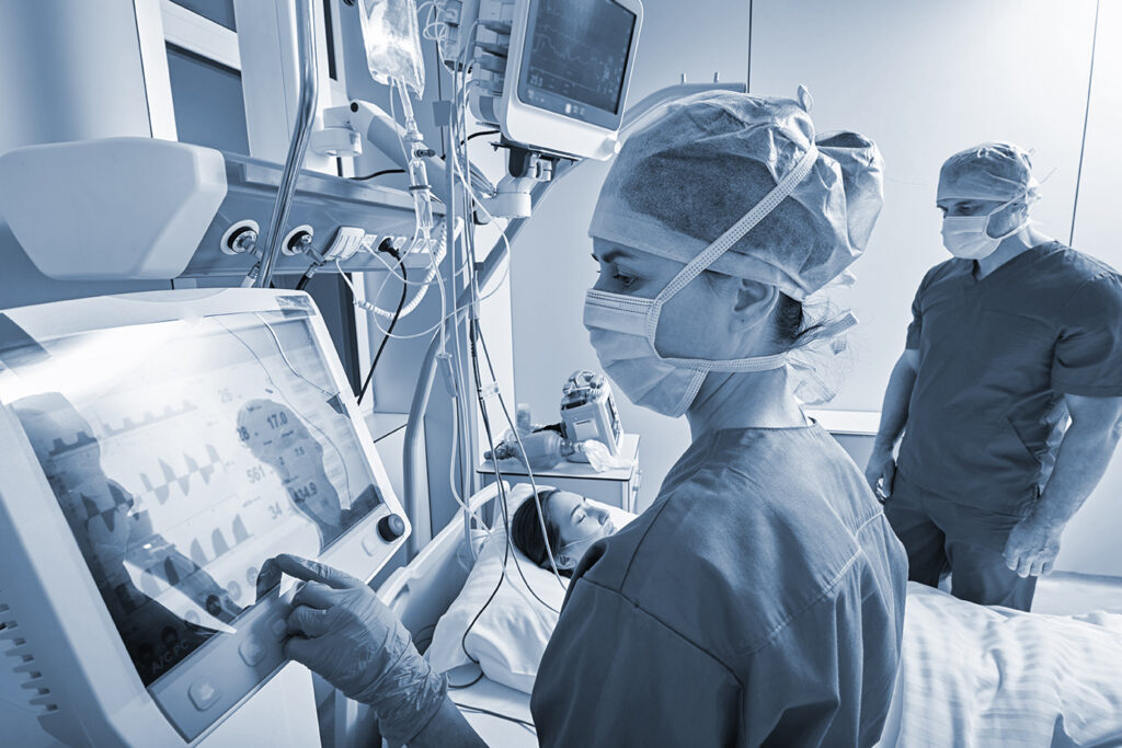 Hospital nurses checking on woman patient at intensive care unit