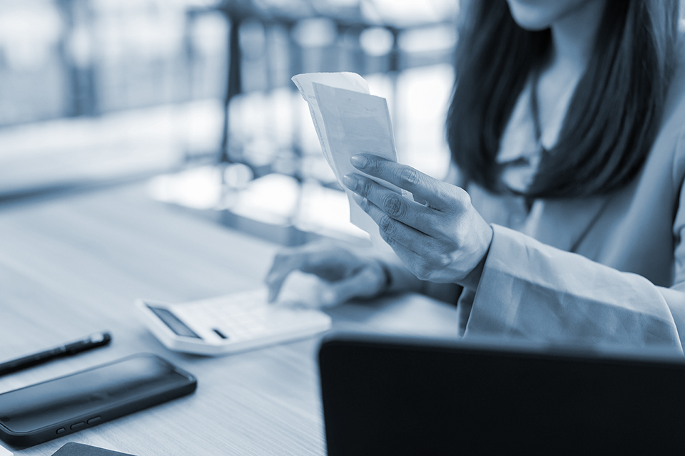 Woman uses calculator to tally up receipts